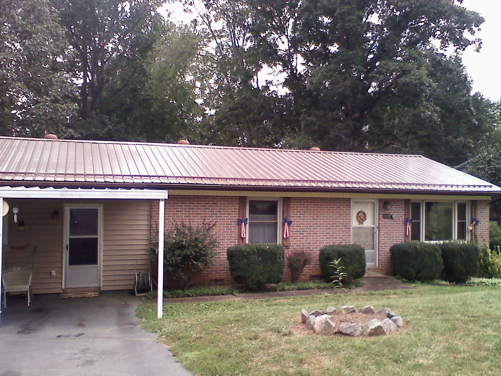 Bronze metal roof and carport on a brick ranch home — Roof Repair work by our crew in Huguenot